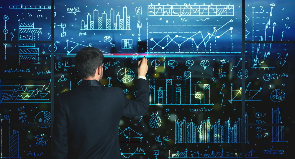 Businessman drawing business statistics on glass wall